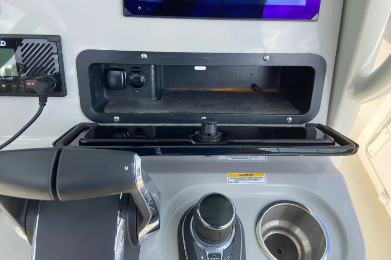 Slide: The Image of Dashboard of a 2025 Boston Whaler 280 Outrage boat with controls and storage compartment. - 42