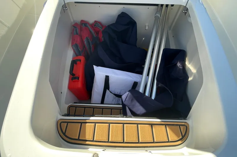 Slide: The Image of Storage compartment of 2025 Boston Whaler 280 Outrage with life jackets and equipment. - 58