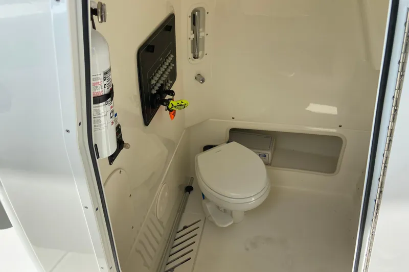 Slide: The Image of 2025 Boston Whaler 280 Outrage interior with toilet and fire extinguisher. - 61