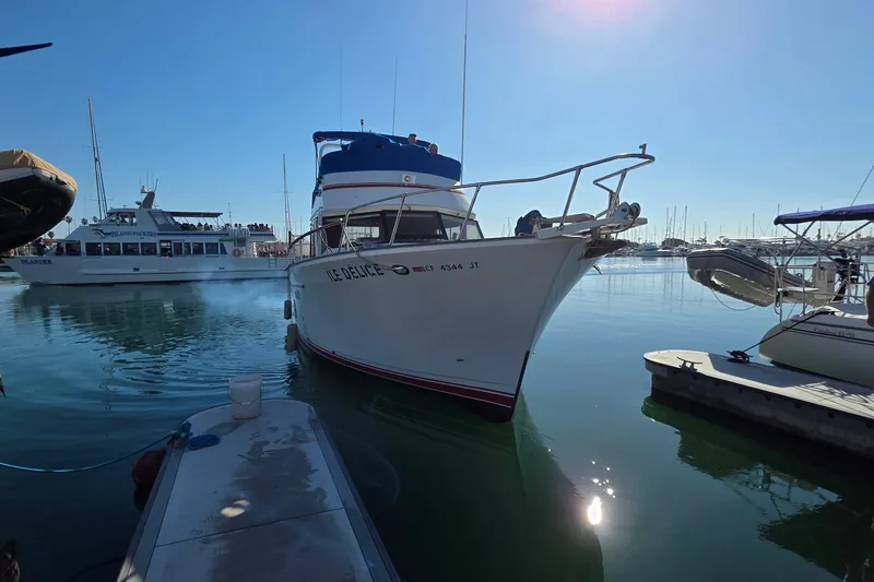 Slide: The Image of 1983 Sea Ranger 45 Sun Deck yacht docked in a sunny marina. - 1