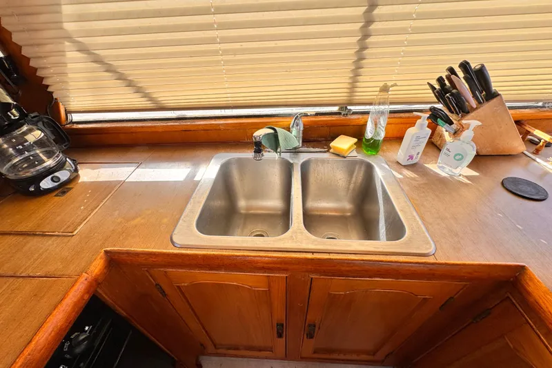 Slide: The Image of 1983 Sea Ranger 45 Sun Deck kitchen with double sink, wooden cabinets, and countertop essentials. - 11