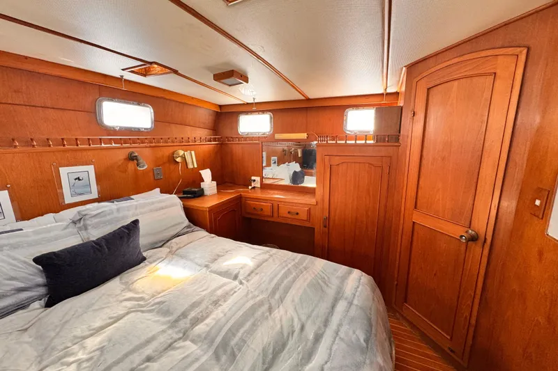 Slide: The Image of Cozy bedroom interior of 1983 Sea Ranger 45 Sun Deck yacht with wooden furnishings. - 13