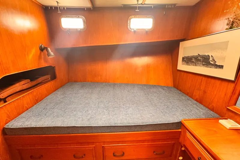 Slide: The Image of Cozy cabin interior of 1983 Sea Ranger 45 Sun Deck with wooden finish and blue mattress. - 17