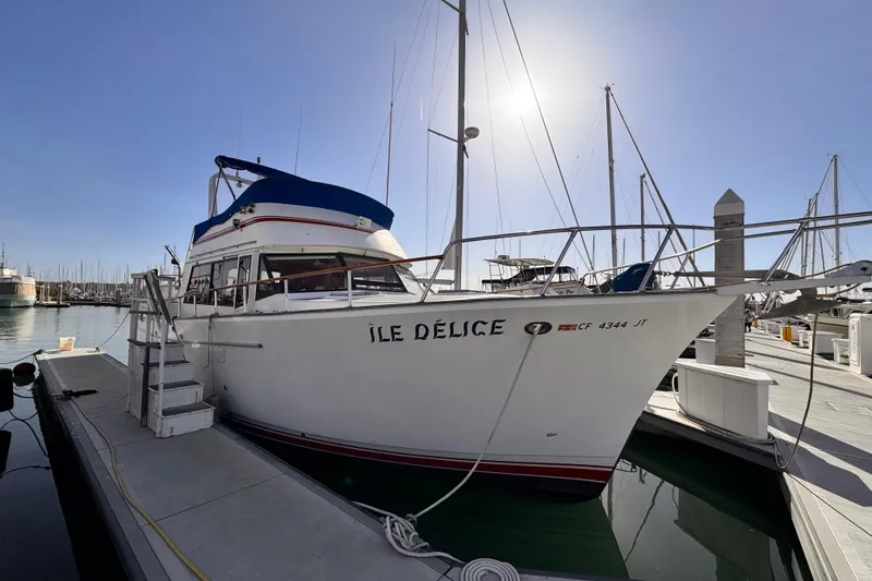 Slide: The Image of 1983 Sea Ranger 45 Sun Deck yacht docked at marina under clear sky. - 2