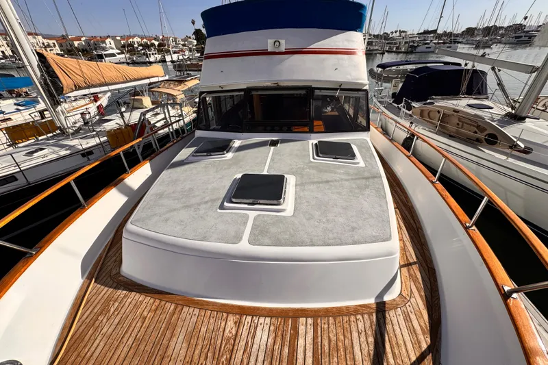 Slide: The Image of 1983 Sea Ranger 45 Sun Deck yacht docked at marina, showcasing spacious deck and sleek design. - 22