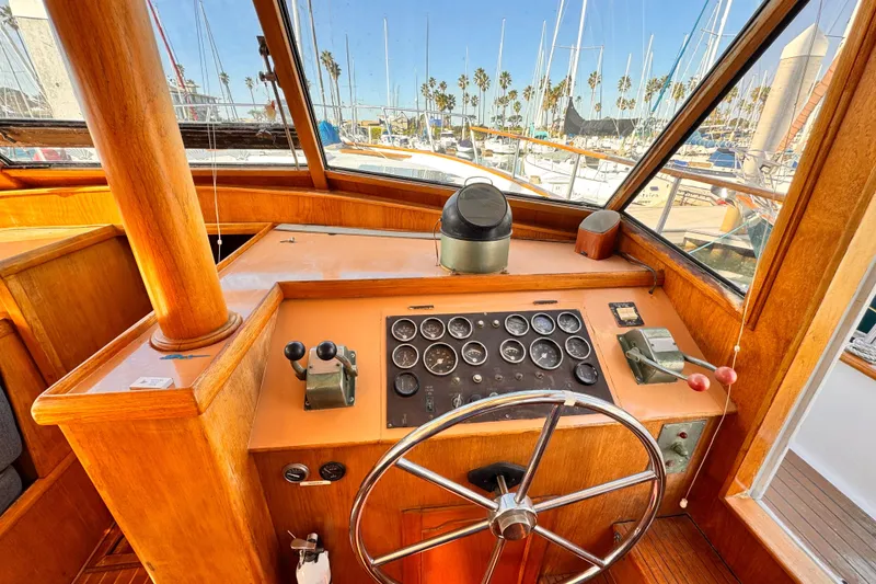 Slide: The Image of 1983 Sea Ranger 45 Sun Deck helm with classic wooden dashboard and steering wheel. - 7
