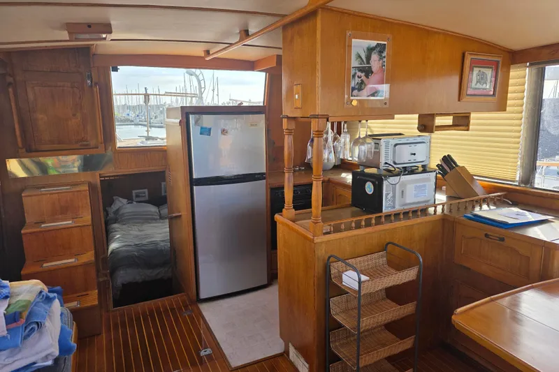 Slide: The Image of 1983 Sea Ranger 45 Sun Deck interior with kitchen, bed, and wooden cabinetry. - 8