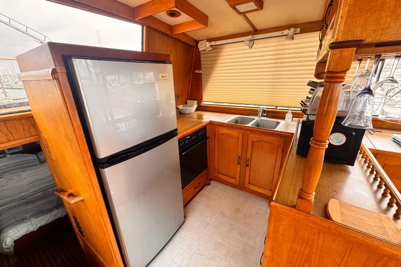 Slide: The Image of 1983 Sea Ranger 45 Sun Deck kitchen with wooden cabinetry and modern appliances. - 9