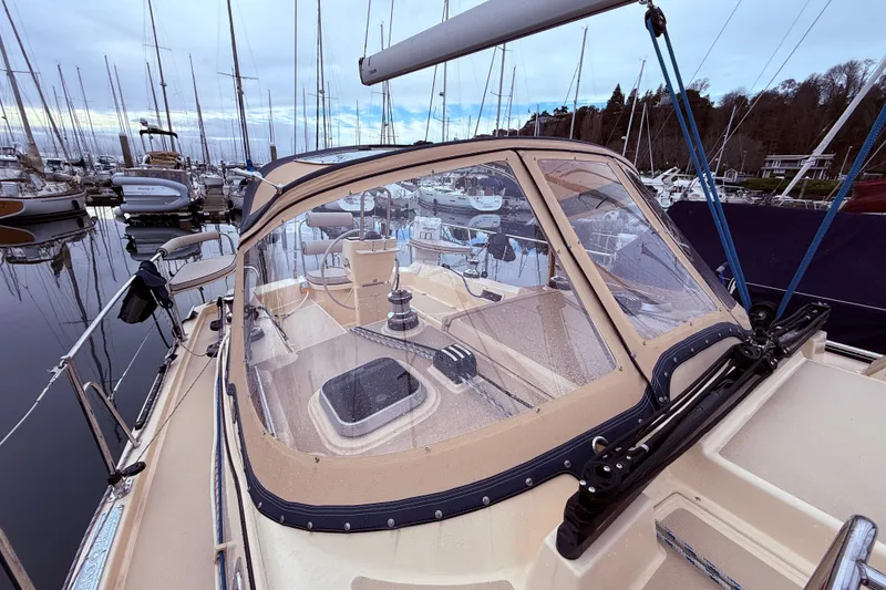 Slide: The Image of 2025 Island Packet 349 sailboat docked in marina, featuring spacious cockpit and protective canopy. - 12