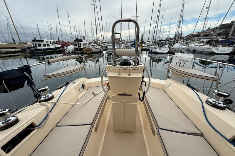 Slide: The Image of 2025 Island Packet 349 sailboat cockpit in marina, surrounded by various docked boats. - 14