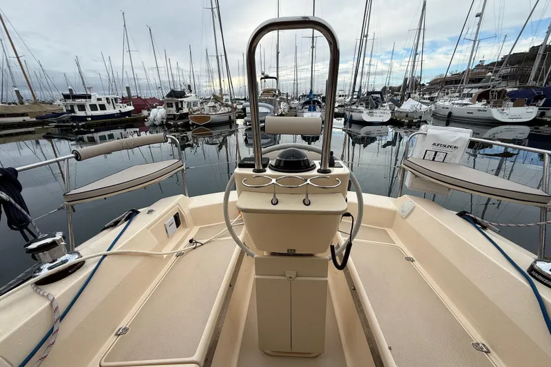 Slide: The Image of 2025 Island Packet 349 sailboat cockpit with marina view, showcasing helm and seating area. - 15