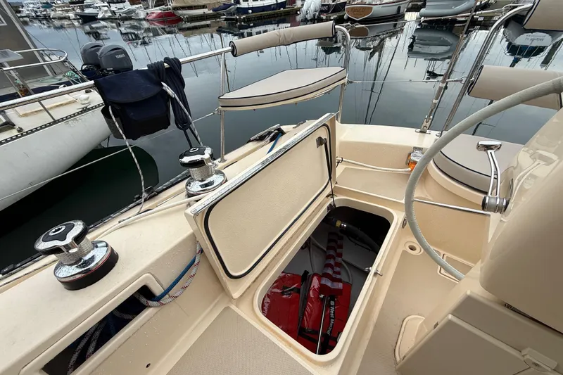 Slide: The Image of 2025 Island Packet 349 sailboat cockpit with open storage compartment at marina. - 16