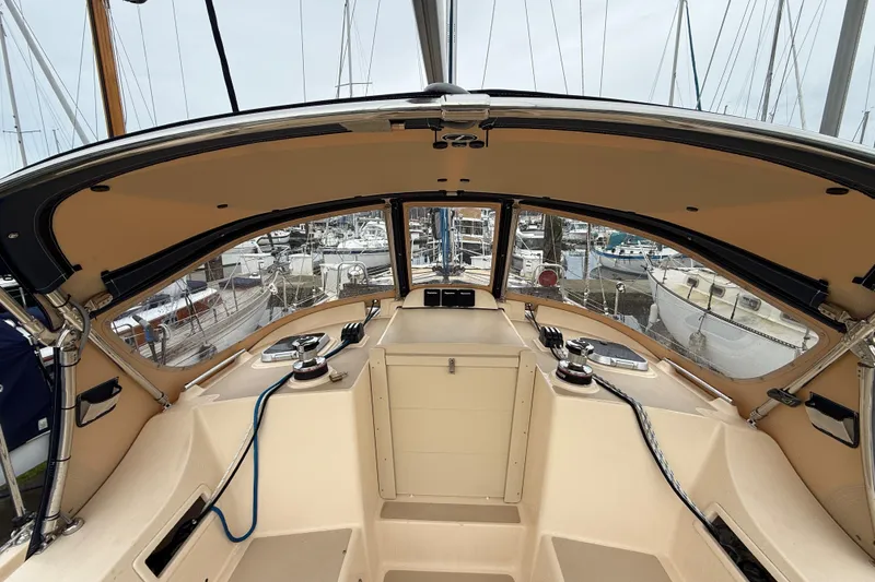 Slide: The Image of 2025 Island Packet 349 sailboat cockpit with marina view, showcasing helm and winches. - 17