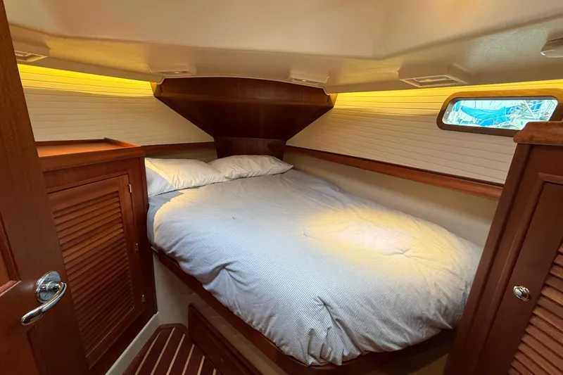 Slide: The Image of Cozy cabin interior of 2025 Island Packet 349 sailboat with wooden accents and comfortable bedding. - 23
