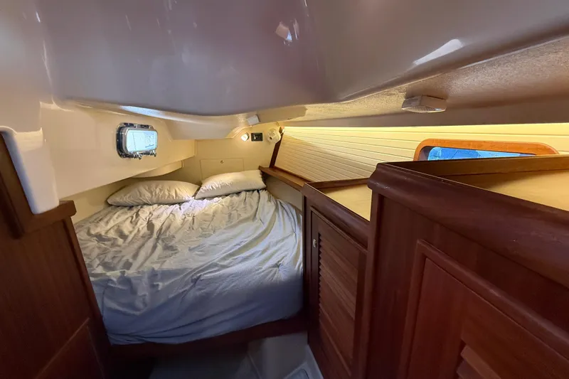 Slide: The Image of Cozy cabin interior of 2025 Island Packet 349 sailboat with bed and wooden cabinetry. - 28