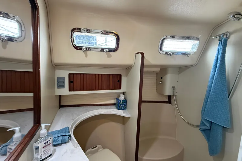 Slide: The Image of 2025 Island Packet 349 yacht bathroom with portholes, shower, and wooden cabinetry. - 30