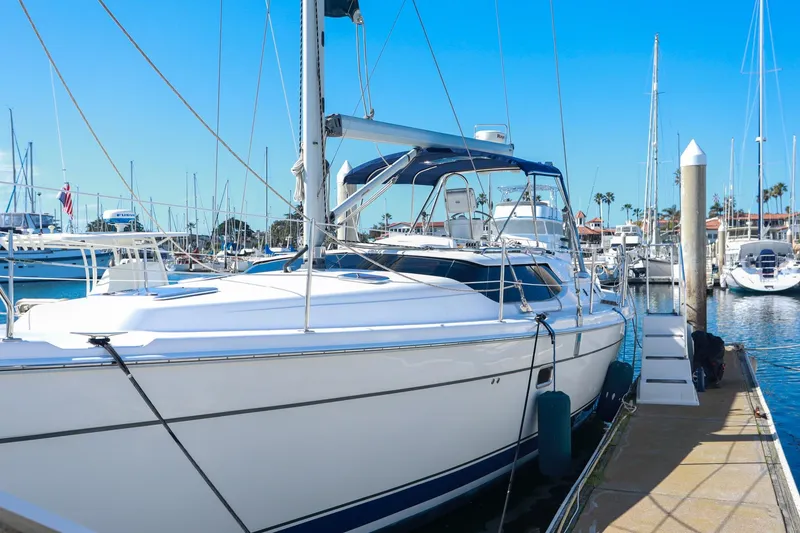 The Image of 2009 Hunter 45 Center Cockpit yacht docked at marina under clear blue sky. - 1