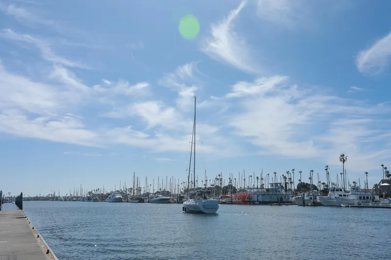 Slide: The Image of Sailboats docked at a marina under a clear blue sky, featuring a 2009 Hunter 45 Center Cockpit. - 11