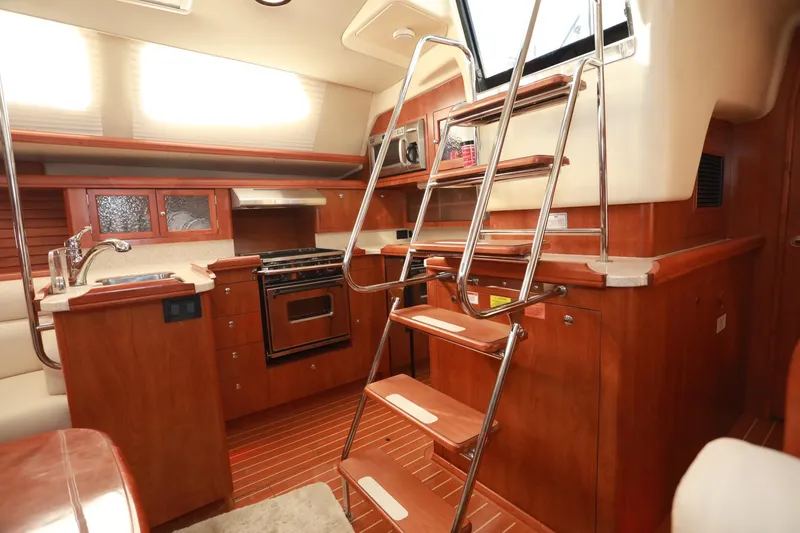 Slide: The Image of Luxurious 2009 Hunter 45 Center Cockpit interior with modern kitchen and wooden cabinetry. - 18
