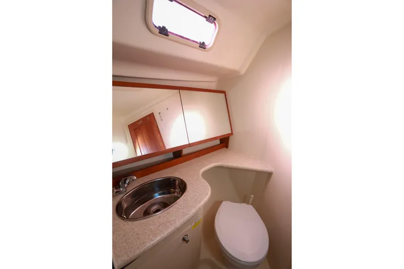Slide: The Image of 2009 Hunter 45 Center Cockpit bathroom with sink, mirror, and toilet. - 32