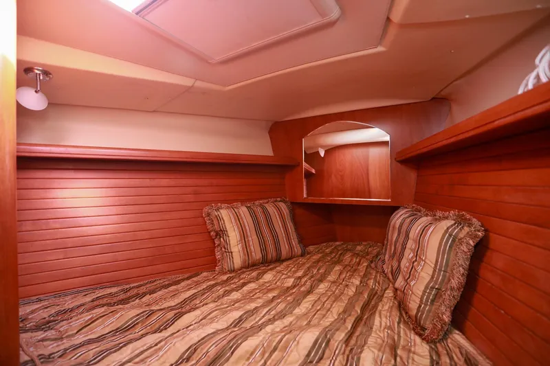 Slide: The Image of Cozy cabin interior of 2009 Hunter 45 Center Cockpit with wood paneling and striped bedding. - 34