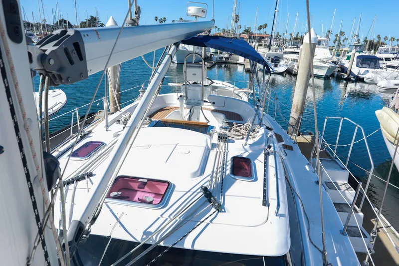 Slide: The Image of 2009 Hunter 45 Center Cockpit sailboat docked in marina, featuring spacious deck and blue canopy. - 6