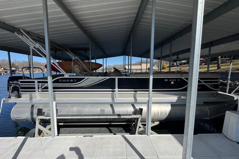 The Image of 2011 Crest 250SLR Caribbean pontoon boat docked under a covered marina. - 0