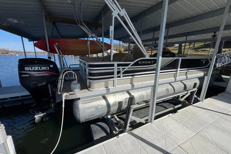 Slide: The Image of 2011 Crest 250 SLR Caribbean boat side view under covered dock. - 1