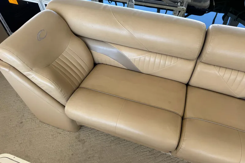 Slide: The Image of Luxurious seating on a 2011 Crest 250SLR Caribbean boat, featuring beige upholstery and cup holders. - 15