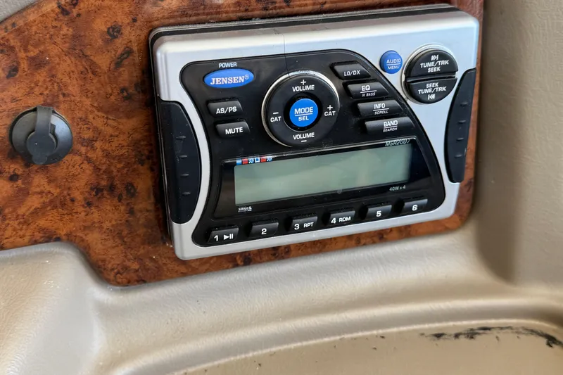 Slide: The Image of 2011 Crest 250SLR Caribbean pontoon boat with Suzuki outboard motor docked under a canopy. - 23