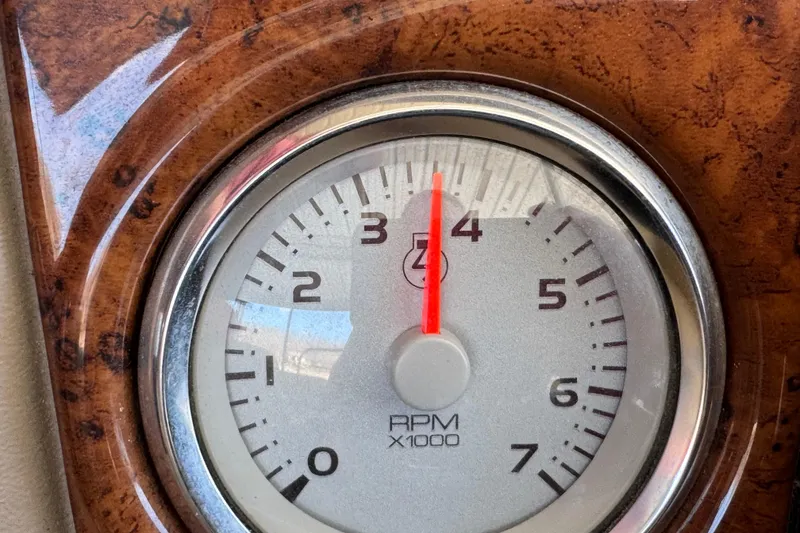 Slide: The Image of Pontoon boat interior with beige cover, docked near a vibrant kayak. Crest 250SLR Caribbean, 2011 model. - 24