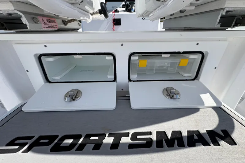 Slide: The Image of 2025 Sportsman Heritage 261 Center Console storage compartments with secure latches and branding. - 12