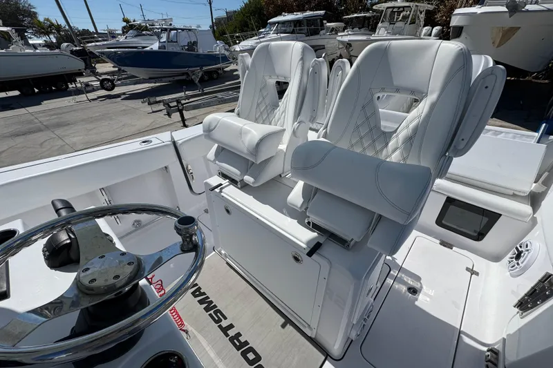 Slide: The Image of 2025 Sportsman Heritage 261 Center Console boat with luxurious white seating and steering wheel. - 14