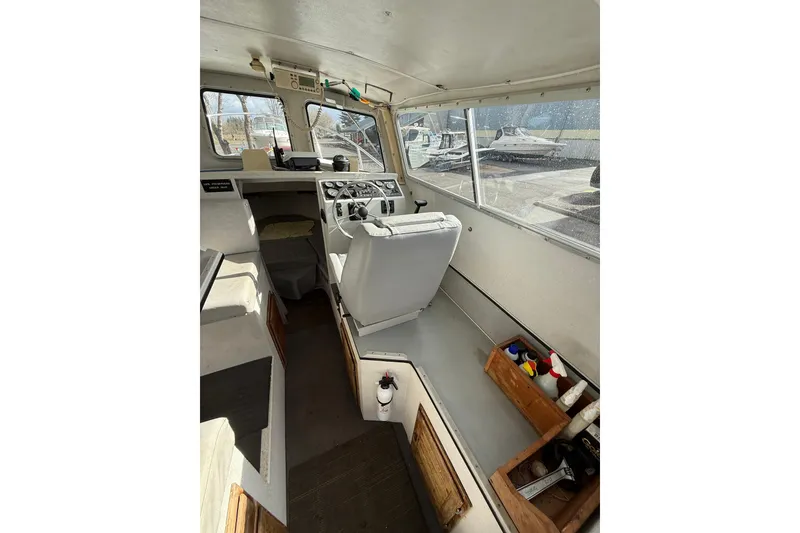 Slide: The Image of Interior of a 1999 SeaSport Seamaster 2700 boat, featuring helm and seating area. - 14