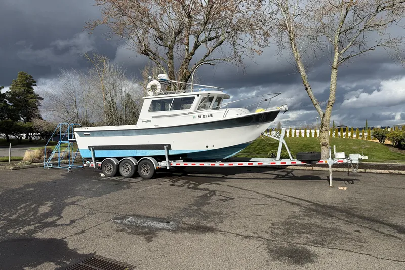 Slide: The Image of 1999 SeaSport Seamaster 2700 boat on trailer under cloudy sky. - 23
