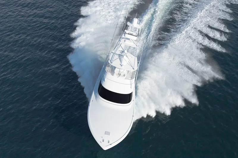 Slide: The Image of Manufacturer Provided Image: 2026 Viking 58 Convertible yacht cruising swiftly on open water. - 2
