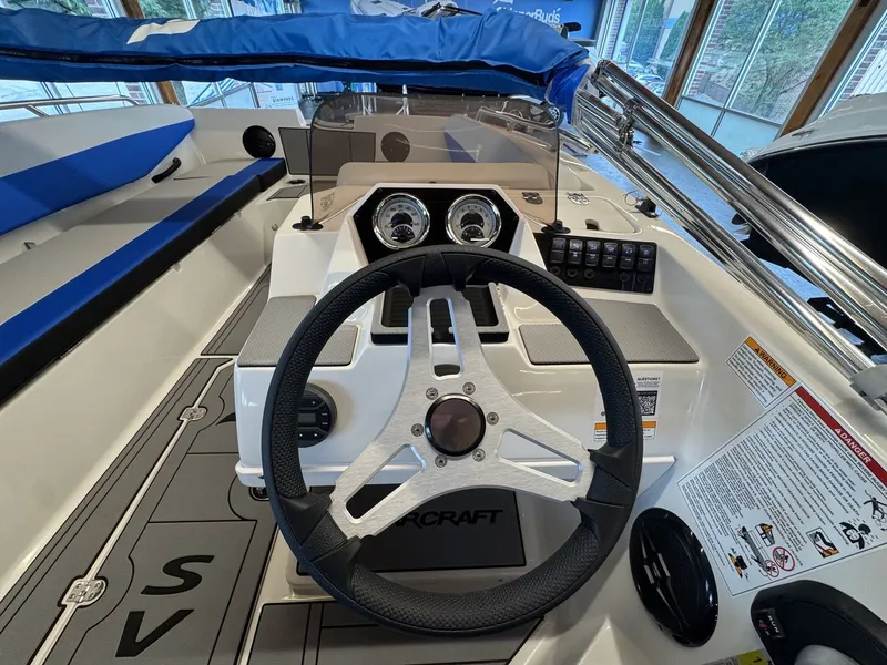 Slide: The Image of The image shows the helm of a Starcraft 181SVOB boat with a modern steering wheel and instruments. - 9