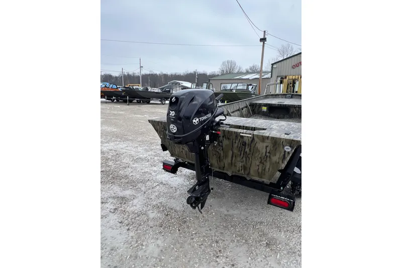 Slide: The Image of 2026 SeaArk 1648 MV Special boat with Tohatsu outboard motor in a gravel lot. - 3