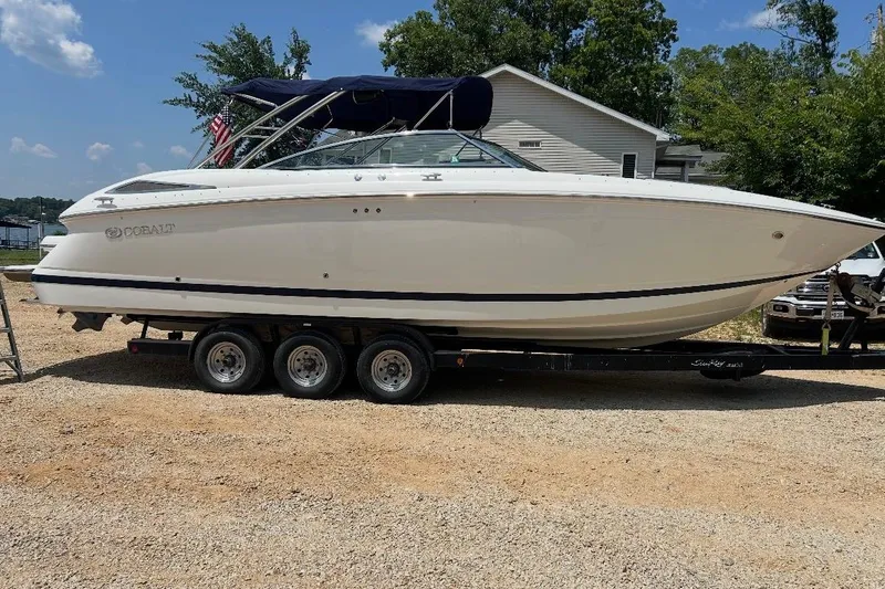 The Image of 2007 Cobalt 302 boat on trailer, parked outdoors, sunny day. - 0