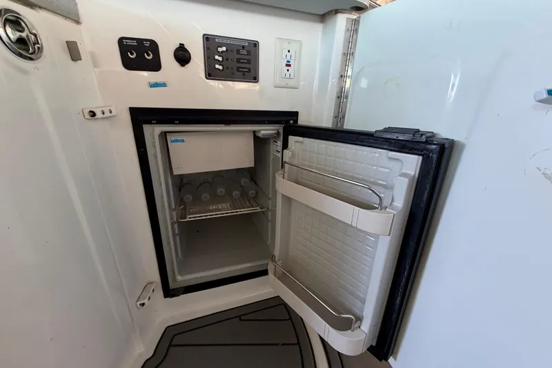 Slide: The Image of Open mini fridge inside 2007 Cobalt 302 boat, showing interior shelves and control panel. - 20