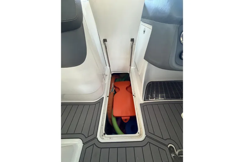 Slide: The Image of Storage compartment in 2007 Cobalt 302 boat with orange and green items inside. - 34