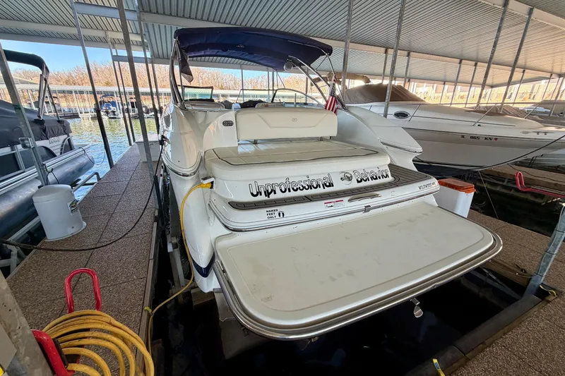 Slide: The Image of 2007 Cobalt 302 boat docked in a marina, rear view with covered seating. - 6
