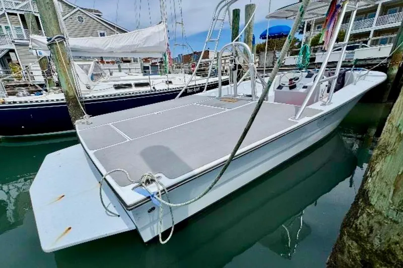 Slide: The Image of 2003 O.C. Parasail 28 boat docked in a marina, featuring a spacious deck. - 6