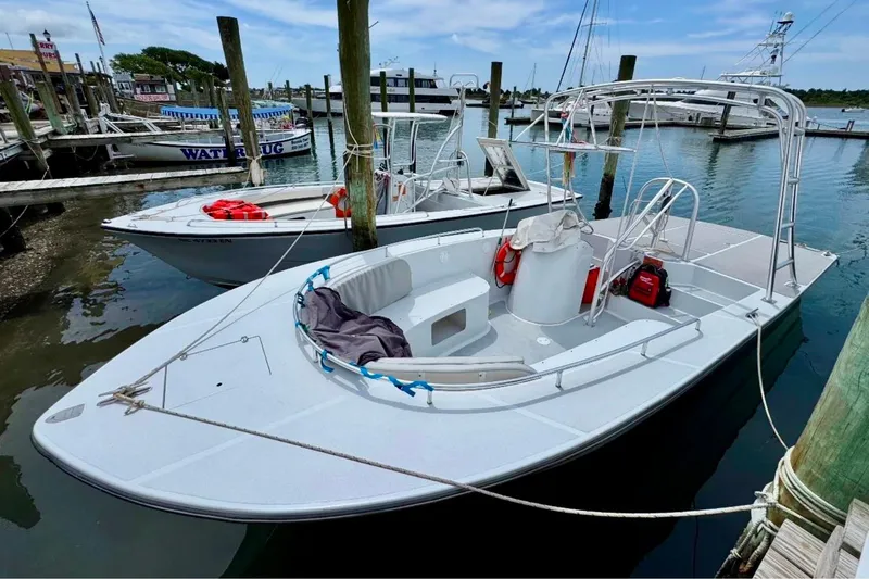 Slide: The Image of 2003 O.C. Parasail 28 boat docked at marina, featuring open deck and safety equipment. - 4