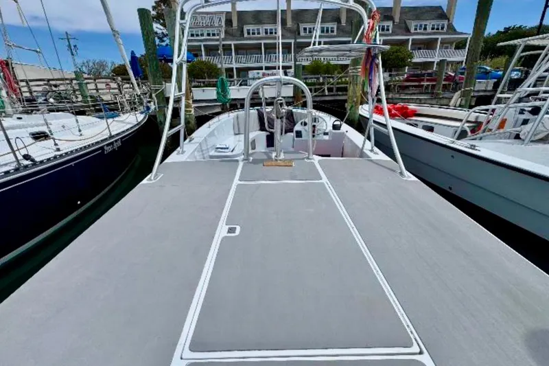 Slide: The Image of 2003 O.C. Parasail 28 boat docked, featuring spacious deck and marina backdrop. - 7