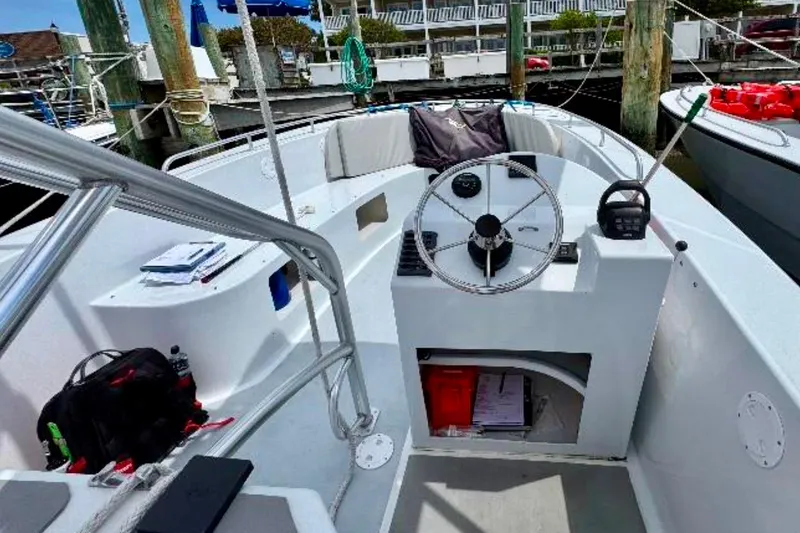 Slide: The Image of Interior of 2003 O.C. Parasail 28 boat with steering wheel and docked surroundings. - 8