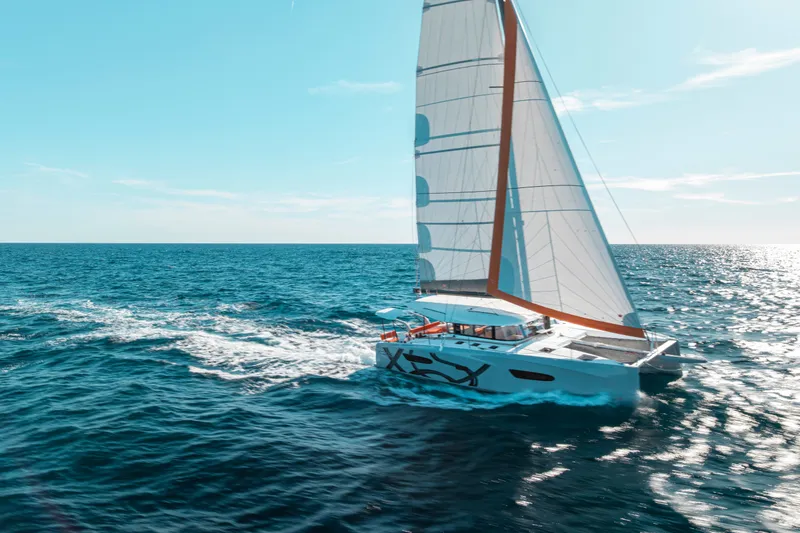 Slide: The Image of Excess 13 catamaran sailing on open sea, 2026 model. - 4
