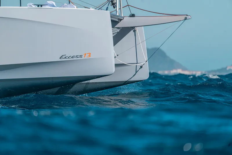 Slide: The Image of Excess 13 catamaran sailing on blue sea, 2026 model. - 2