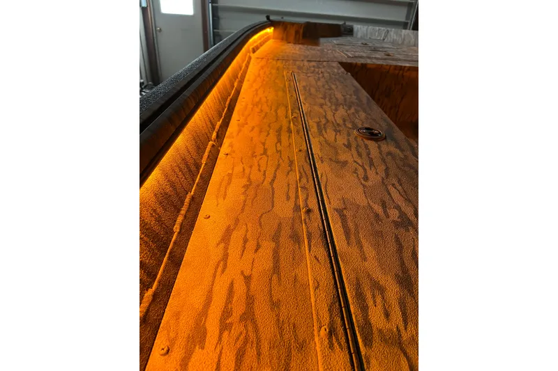 Slide: The Image of 2026 SeaArk 1960 Slayer X boat interior with orange lighting and textured surface. - 3