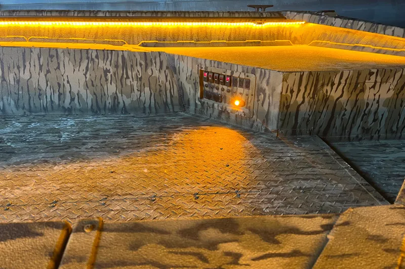 Slide: The Image of 2026 SeaArk 1960 Slayer X boat interior with camo design and illuminated control panel. - 4